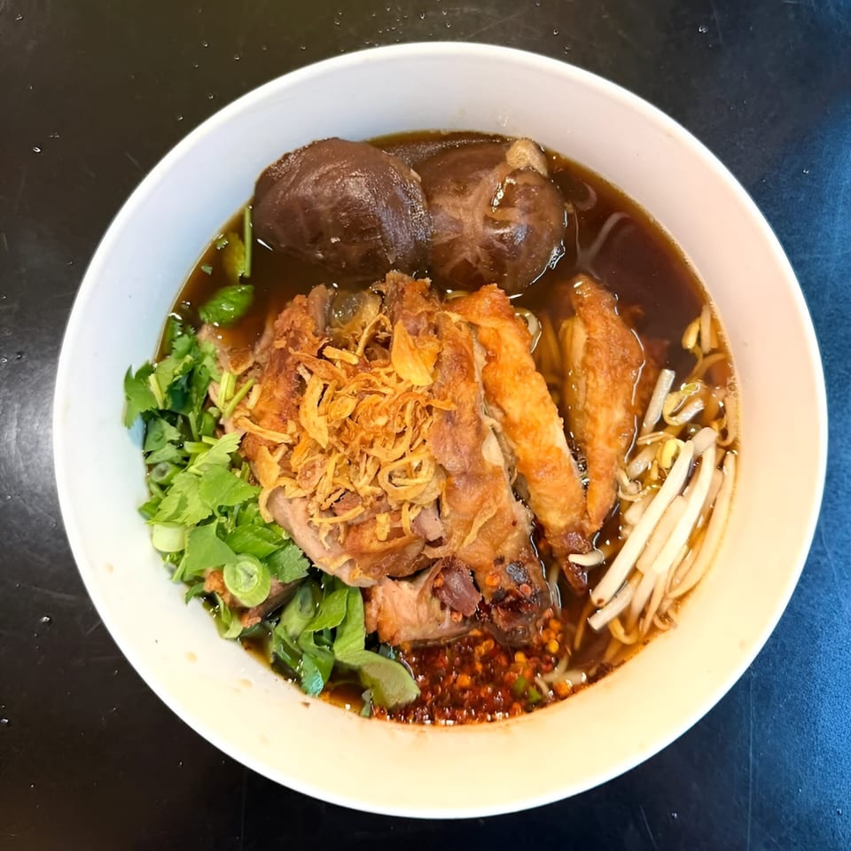 Koo Thai's duck noodle soup with mushrooms, fried onions, bean sprouts, and fresh herbs.